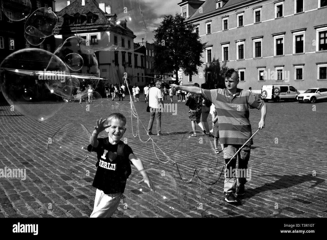 Jouant avec les bulles de savon dans la vieille ville Stare Miasto Varsovie, Place du Château, la capitale de la Pologne. Image en noir et blanc. Banque D'Images