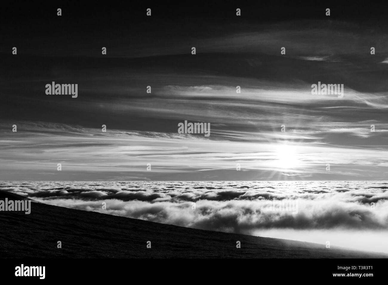 Magnifique coucher de soleil sur une vallée remplie de brouillard avec les montagnes et les collines Banque D'Images