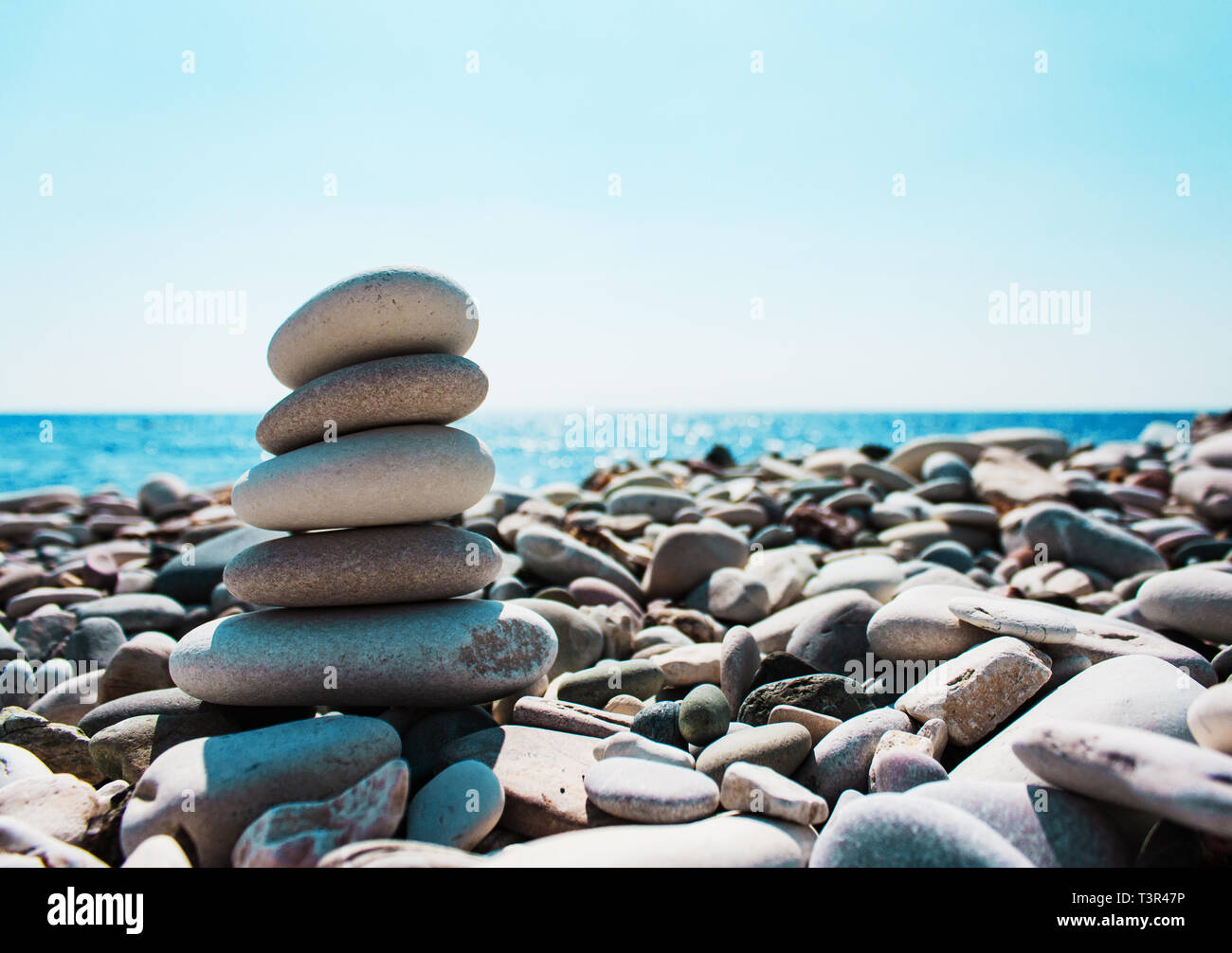 Balance des pierres sur la main sur le fond de la mer. Le concept de la paix de l'esprit, l'harmonie, la spiritualité Banque D'Images