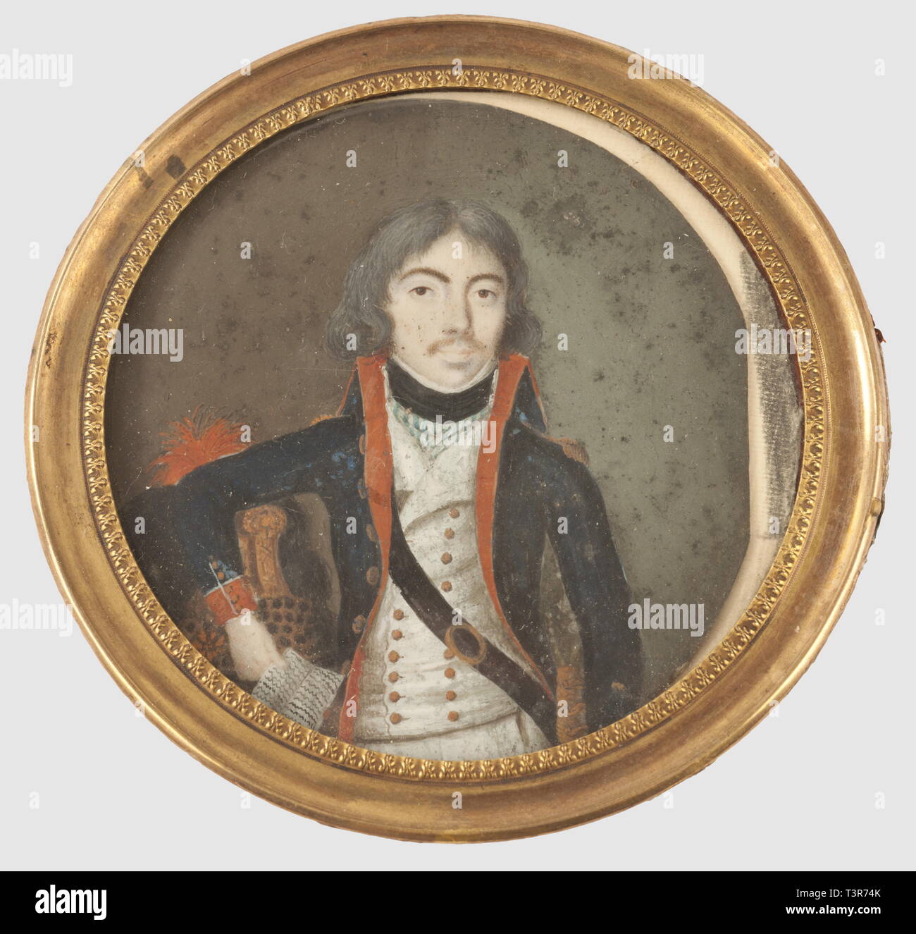 Révolution, Représentation d'un officier d'artillerie volante vers 1790, miniature ronde sur ivoire ( ?), l'officier tient un document dans sa main droite et porte un uniforme à fond de drap bleu foncé, col, parements (fermant à l'aide de 5 boutons) et doublure écarlates. Boutons jaunes, gilet blanc croisé, cravate noire et foulard en tissu rayé bleu et blanc, épaulette en fil d'or, il porte son ceinturon de cuir (noir) en sautoir, la boucle (ovale) et la poignée du sabre sont dorées, en arrière-plan, sur l'apercoit fils casque, du type des dragons, bandea, n'a pas d'auteur de l'artiste pour être effacé Banque D'Images