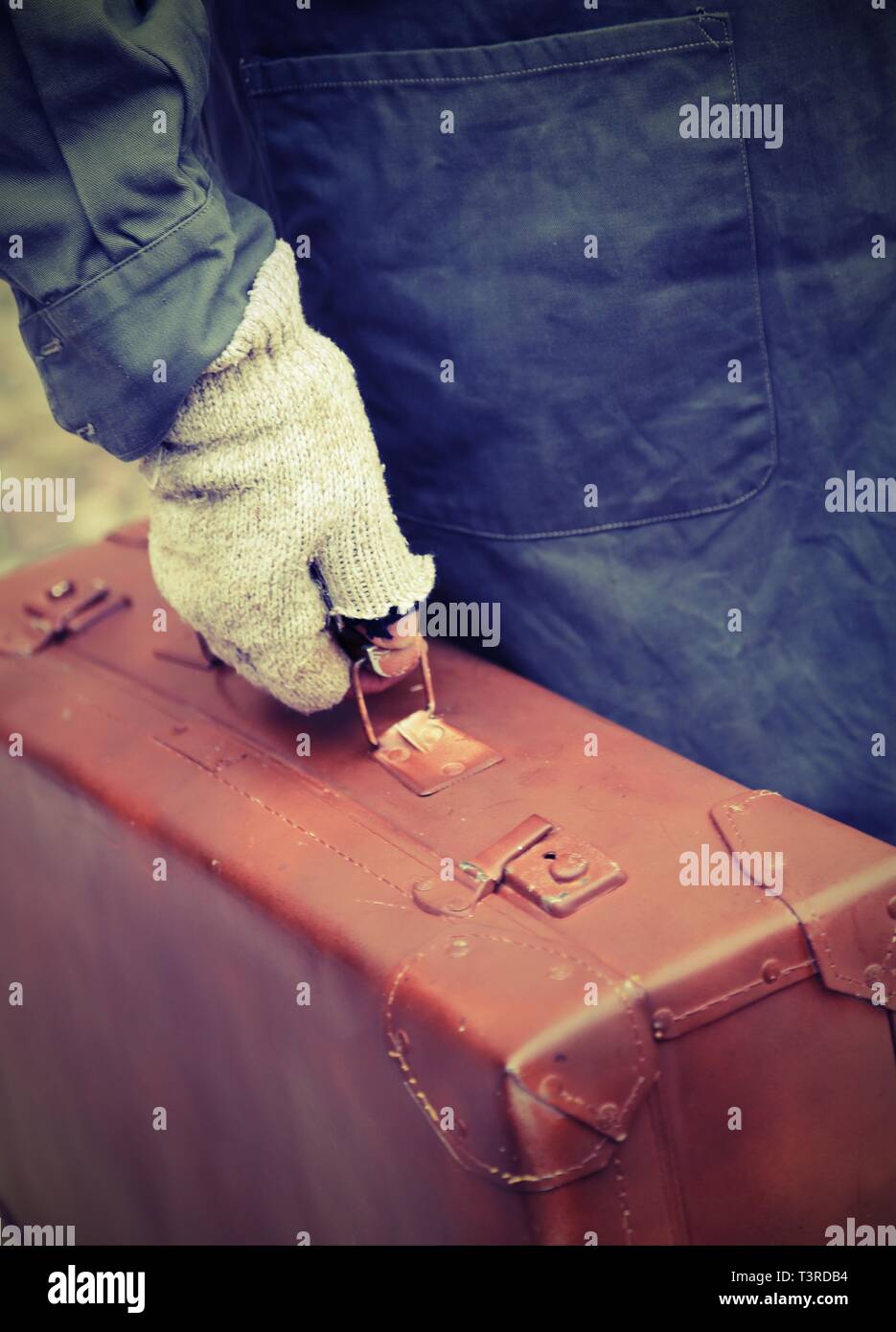 Pauvre homme avec valise en cuir et gants cassée avec de vieux effet tonique Banque D'Images