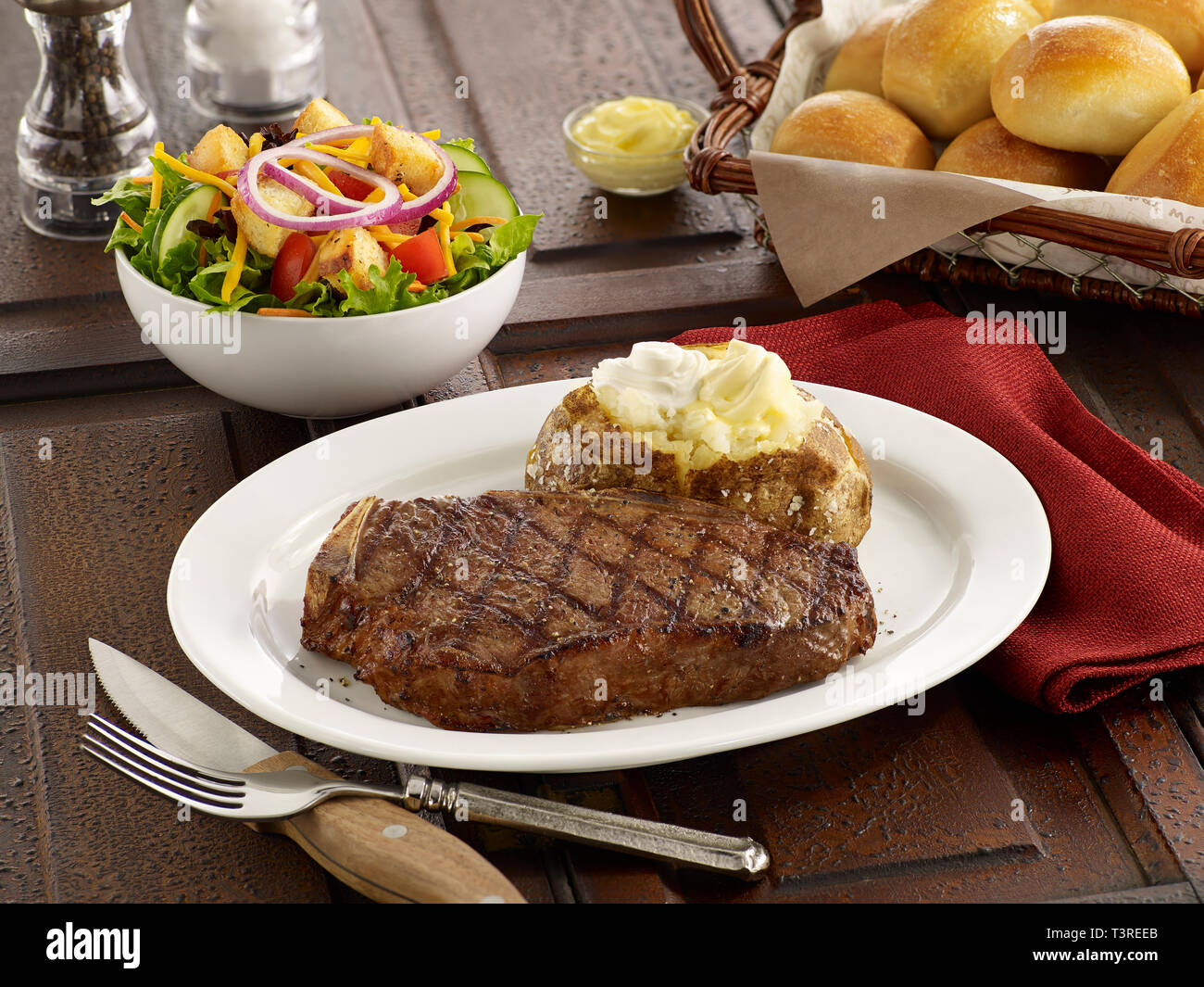Kansas City Steak avec pomme de terre au four et salade Banque D'Images