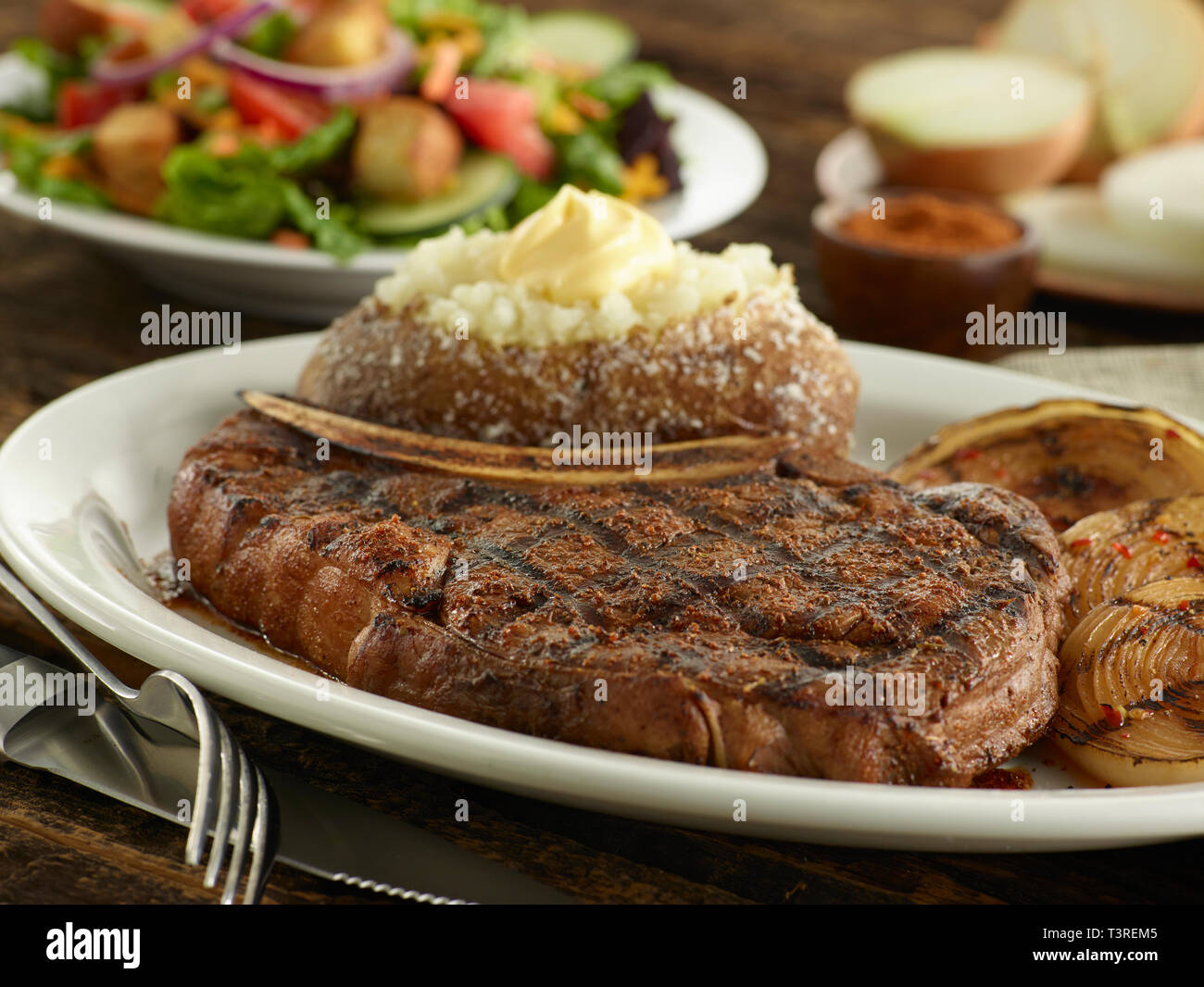 Ribeye Steak noirci avec oignons grillés et salade Banque D'Images