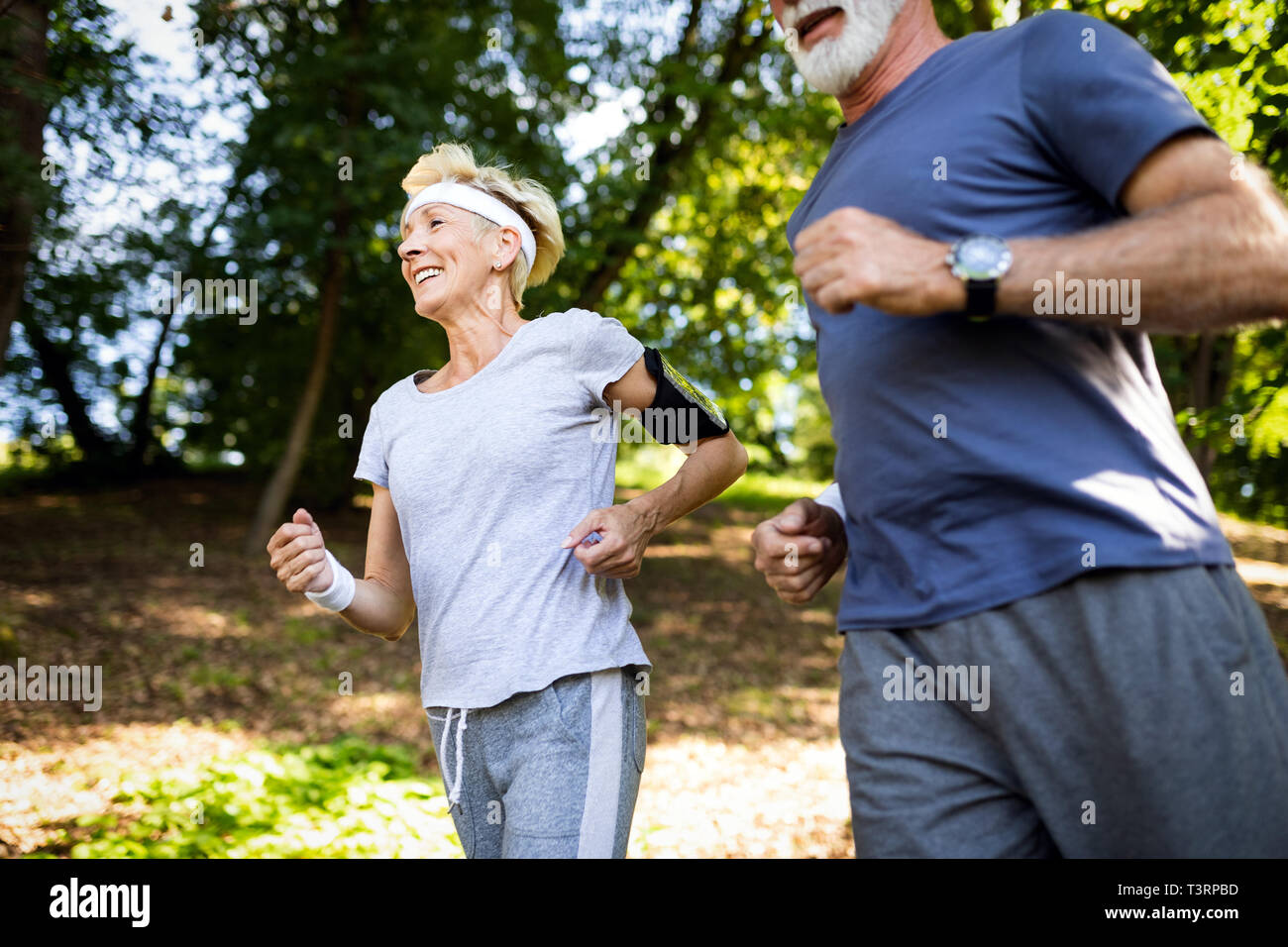 Senior couple jogging et tournant à l'extérieur dans la nature Banque D'Images