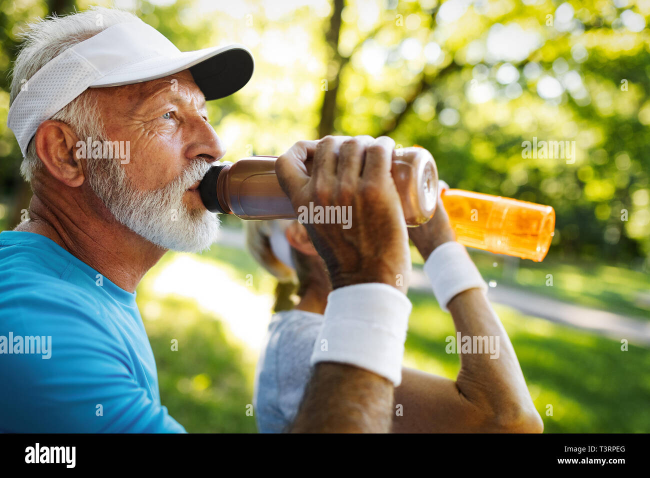 Hydratant. Personne senior sportive de l'eau potable dans un parc Banque D'Images