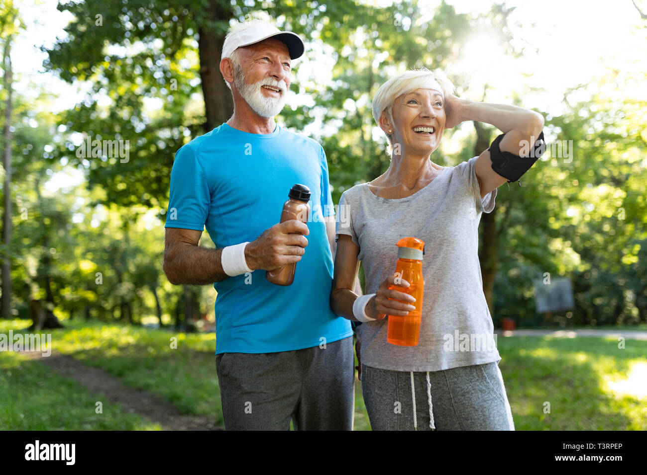 Happy fit senior couple exercising in park Banque D'Images