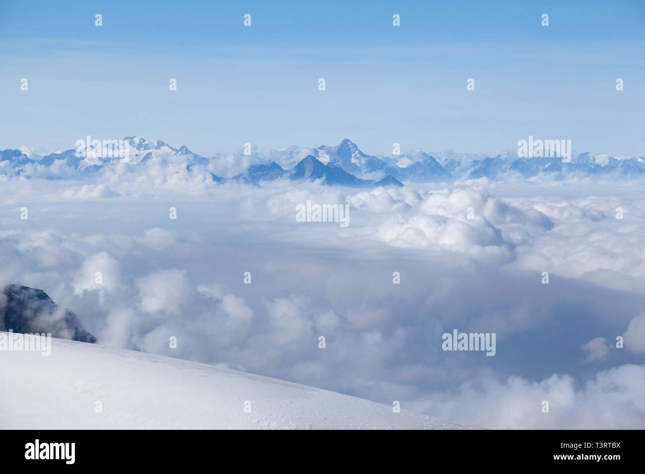 Haut Valais, vue depuis le terminus du téléphérique à 3820m au-dessus de la ligne de nuages vers les montagnes alpines. Banque D'Images