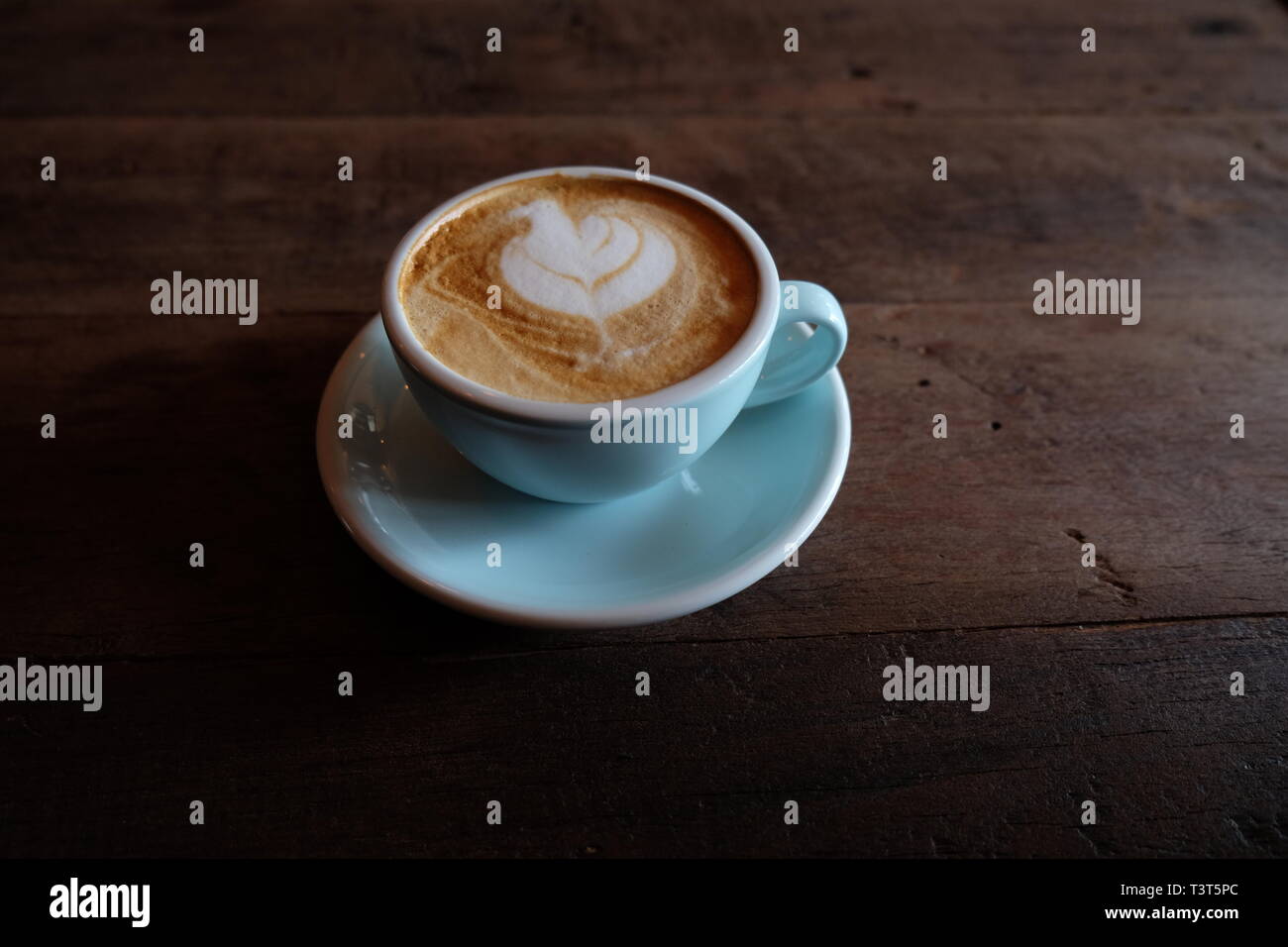 Cappuccino ou latte avec mousse écumeuse, blue Coffee cup top sur fond café en bois Banque D'Images