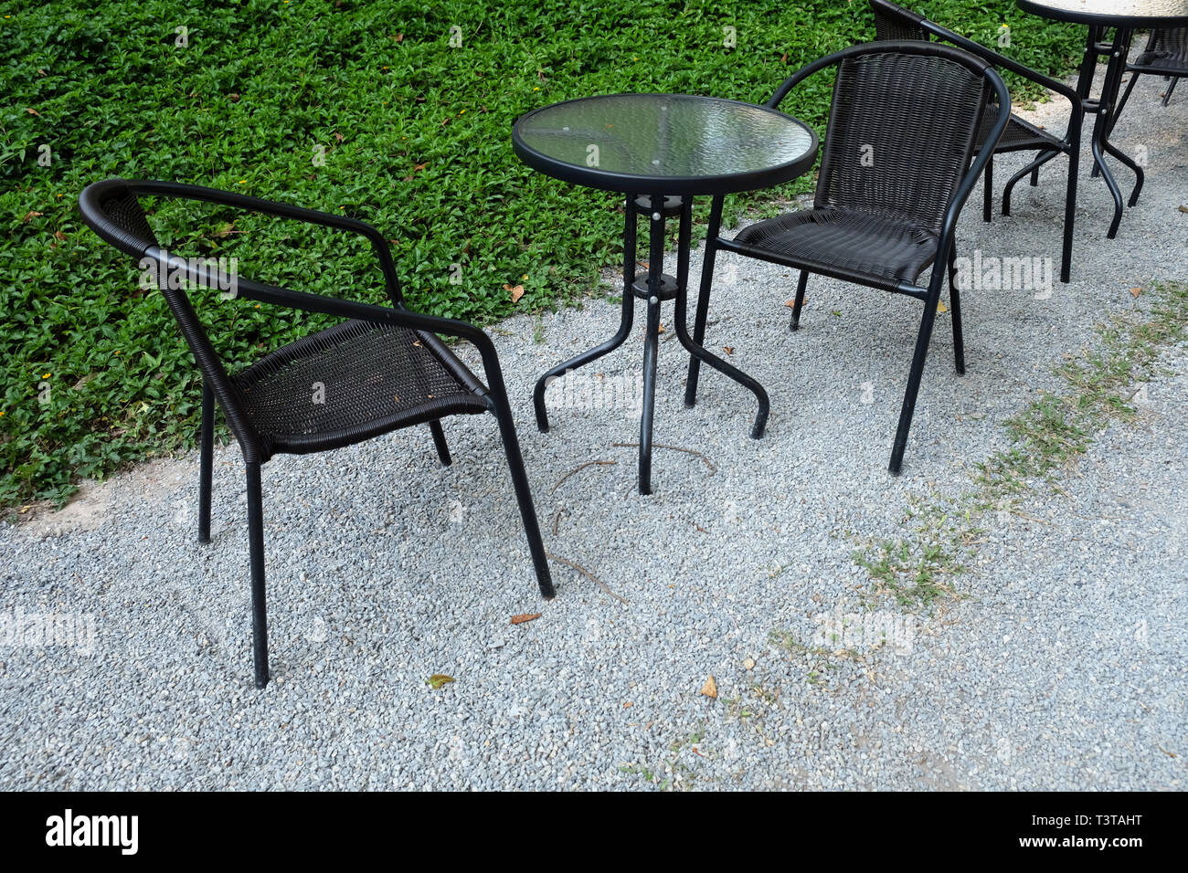 Espace de loisirs de plein air avec chaises et table de fond naturel vert Banque D'Images