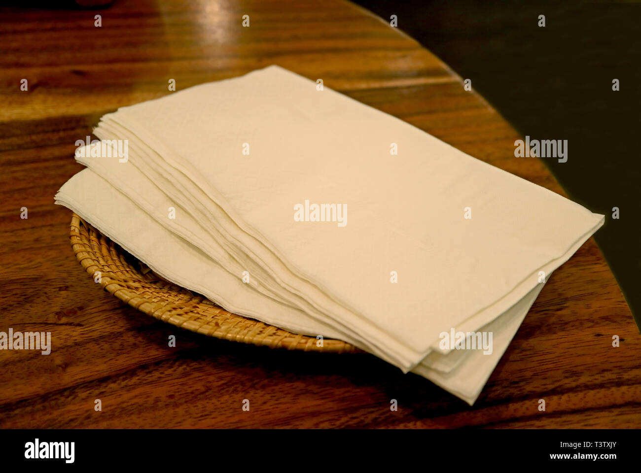 Pile de serviettes en papier sur le plateau de table à manger en osier Banque D'Images