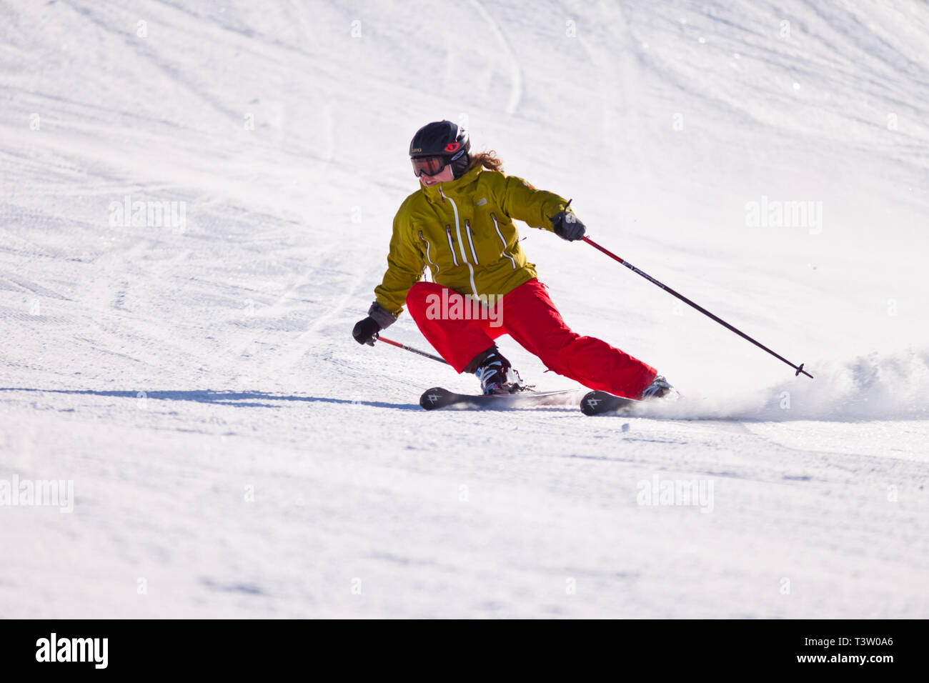 Jeune femme ski de descente sur une pente à une station de ski dans les Rocheuses canadiennes, Alberta, Canada Banque D'Images