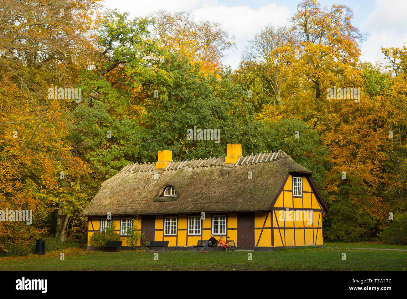 Vieille maison à pans de bois jaune avec toit de chaume en Charlottenlund forêt, Danemark Banque D'Images