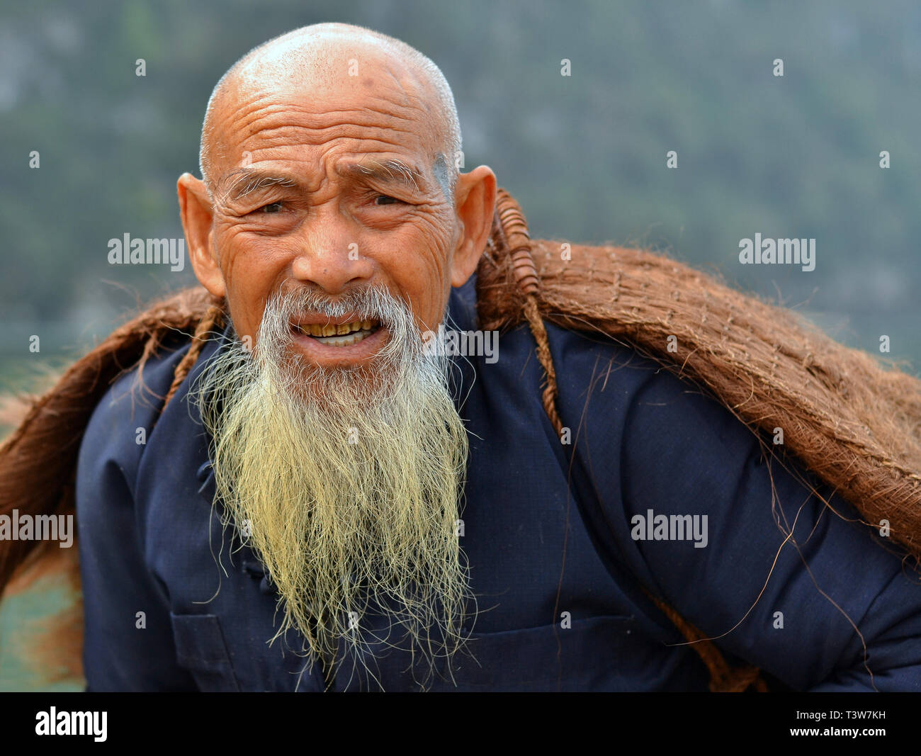 Vieux chauve, cormoran pêcheur chinois avec une longue barbe chinois pose pour la caméra Photo