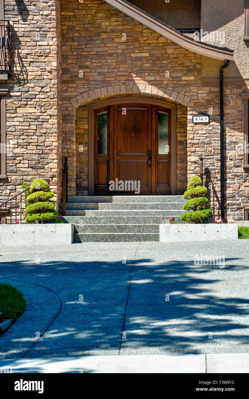 Porte d'entrée de maison de luxe avec béton porte et la décoration des  arbres par côtés Photo Stock - Alamy