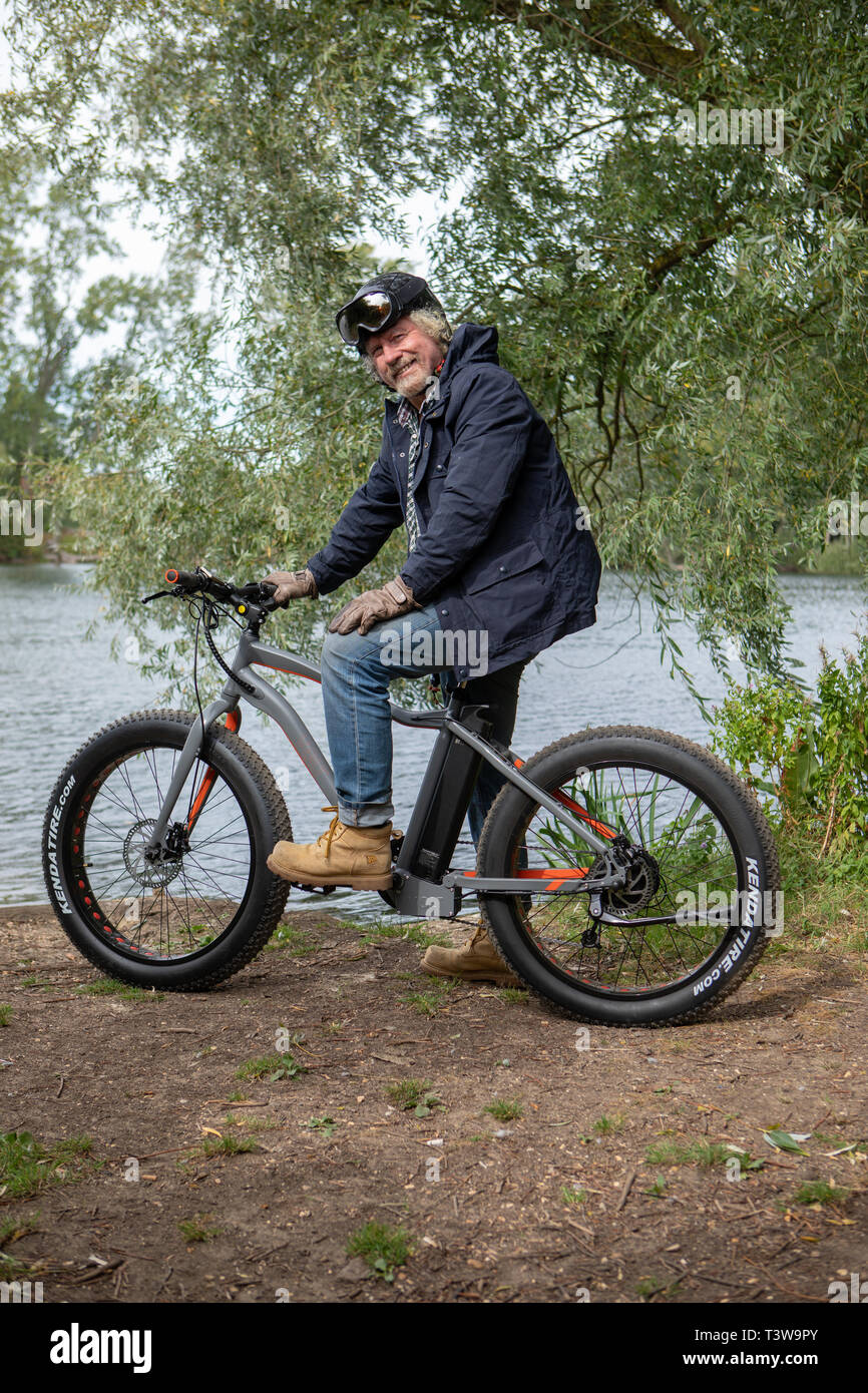 Un homme rides un vélo électrique UK Banque D'Images