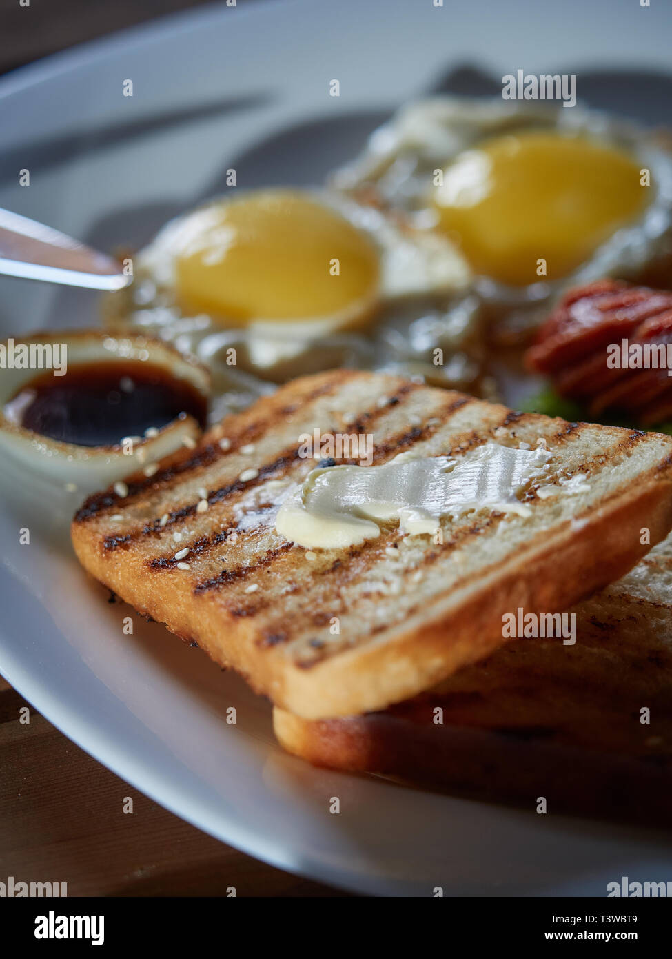 Plusieurs oeufs frits sont servis sur une assiette avec de la saucisse et salade verte avec des tomates rouges frais. Banque D'Images