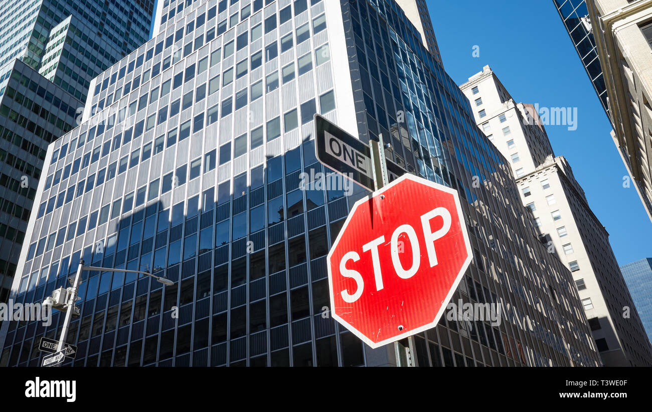 Panneau d'arrêt sur une rue de la ville de New York, les bâtiments modernes en arrière-plan, USA. Banque D'Images