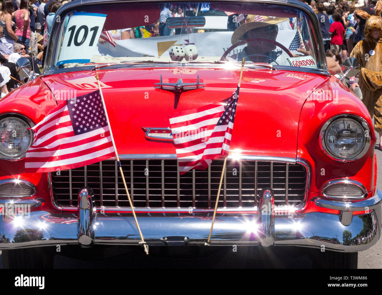 L'homme au volant d'une Chevrolet Bel Air classique automobile voiture décorée de drapeaux américains dans une petite ville traditionnelle parade du 4 juillet Banque D'Images