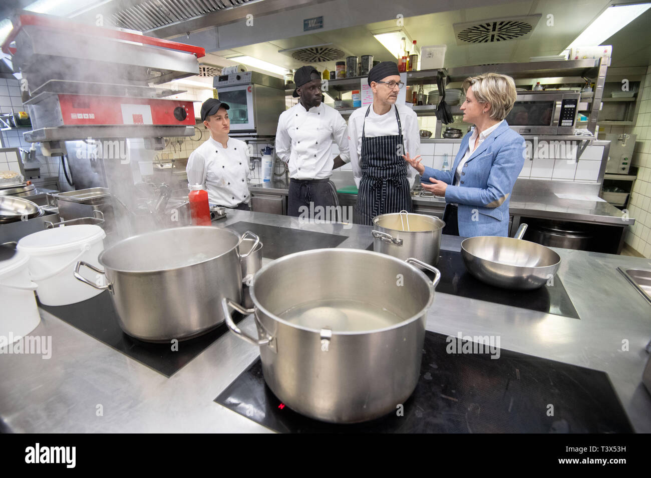 12 avril 2019, Bade-Wurtemberg, Tübingen : Nicole Hoffmeister-Kraut (CDU, r-l), Ministre de l'économie du Bade-Wurtemberg, parle dans la cuisine de l'Landhotel Hirsch avec Anton Mayer, chef, Malik Gui, apprenti cuisinier, et Pia Schmid, apprenti cuisinier. Hoffmeister-Kraut voulait visiter quatre entreprises et découvrez les modèles de temps de travail et la volonté d'entreprises et d'employés. Photo : Marijan Murat/dpa Banque D'Images