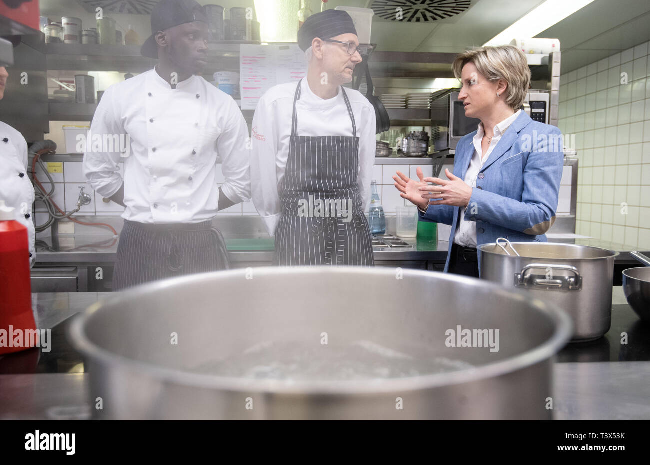 12 avril 2019, Bade-Wurtemberg, Tübingen : Nicole Hoffmeister-Kraut (CDU, r-l), Ministre de l'économie du Bade-Wurtemberg, parle dans la cuisine de l'Landhotel Hirsch avec Anton Mayer, chef, et Malik Gui, stagiaire cuisinier. Hoffmeister-Kraut voulait visiter quatre entreprises et découvrez les modèles de temps de travail et la volonté d'entreprises et d'employés. Photo : Marijan Murat/dpa Banque D'Images