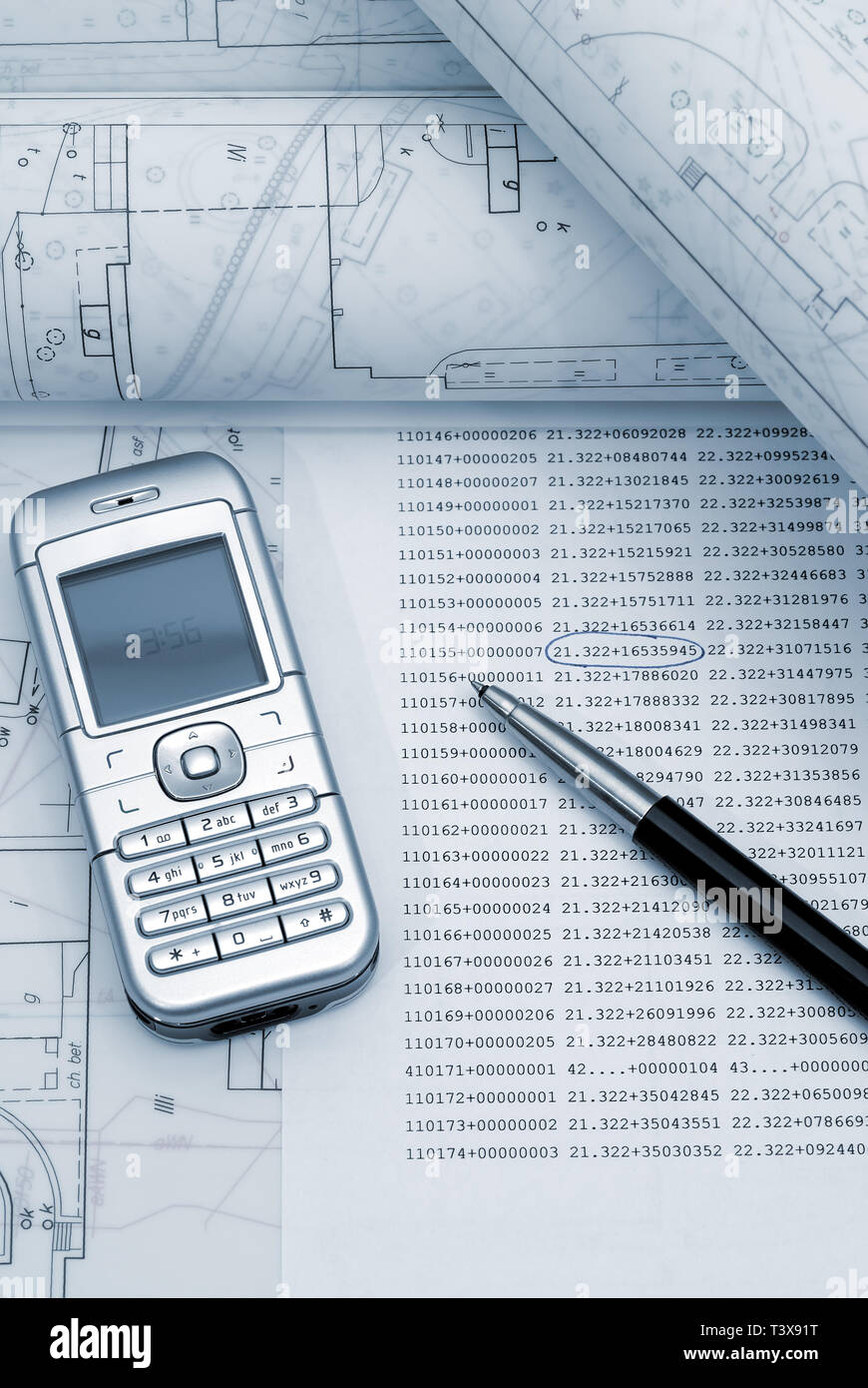 Plans architecturaux laminées avec téléphone et un stylo posé sur table à dessin. Photo de ton bleu. Banque D'Images