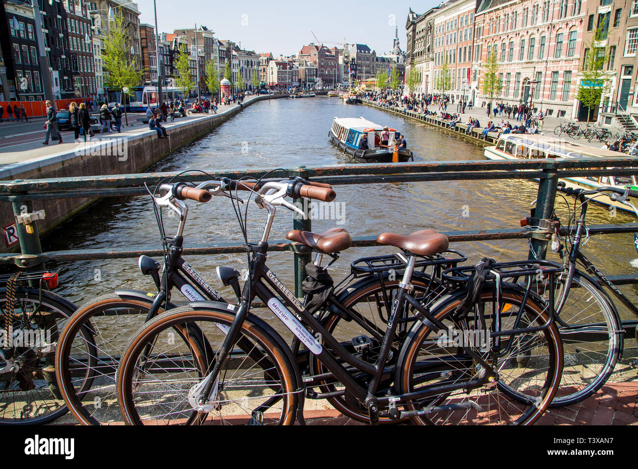 Un pont sur un canal à Amsterdam. Apprendre des vélos sur les rails qu'un bateau peut être vu par la voile. Banque D'Images