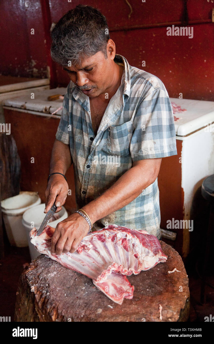 Butcher transformant un carcasse de chèvre, Manning, marché de Pettah, Colombo, Sri Lanka Banque D'Images