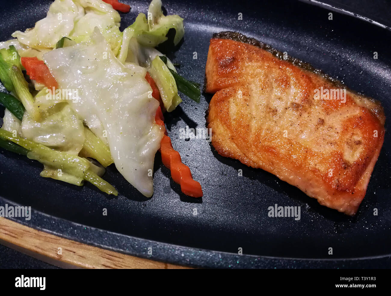 Pavé de saumon avec des légumes sur un gril Banque D'Images