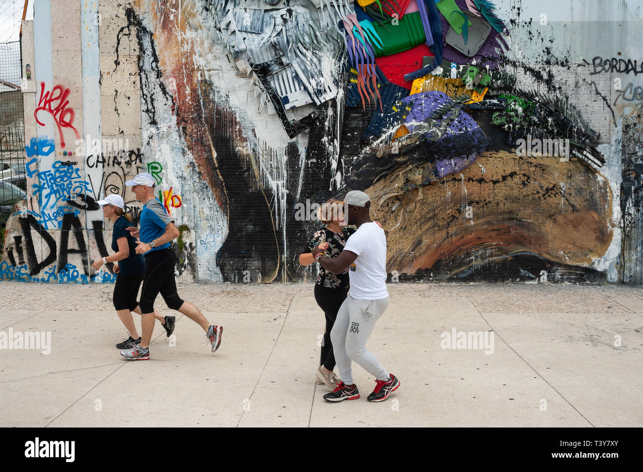 11.06.2018, Lisbonne, Portugal, Europe - un couple danse Lambada sur un trottoir comme deux coureurs sont de passage. Banque D'Images