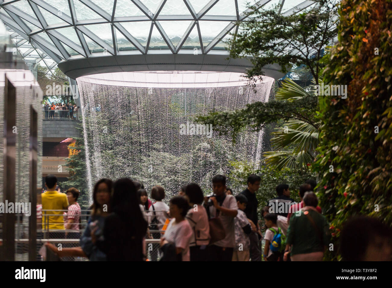 Scène bondée à l'intérieur de l'aéroport Jewel Changi, les gens s'émerveillent devant le Vortex de pluie, la plus haute cascade intérieure du monde se trouve à Singapour. Banque D'Images