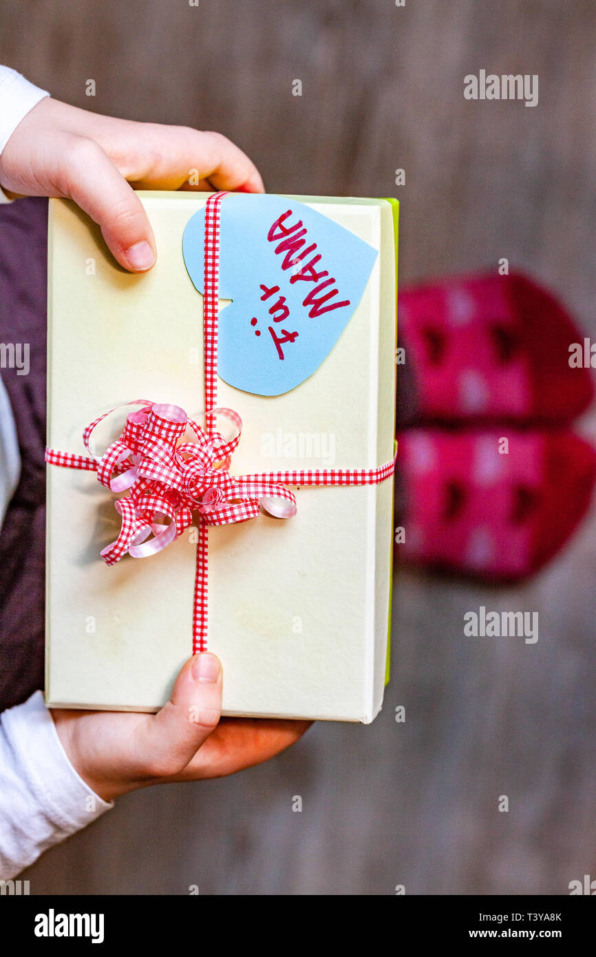 Petit enfant holding gift box avec ruban et coeur pour sa maman - Traduction  : pour maman Photo Stock - Alamy