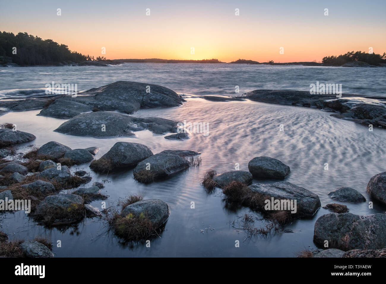 Paysage panoramique sur la mer avec un vent fort et coucher du soleil à soirée d'hiver en Finlande littoral Banque D'Images Paysage panoramique sur la mer avec un vent fort et coucher du soleil à soirée d'hiver en Finlande littoral Banque D'Images