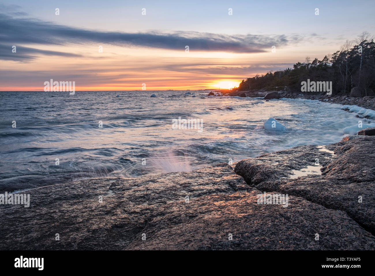 Paysage panoramique sur la mer avec un vent fort et coucher du soleil à soirée d'hiver en Finlande littoral Banque D'Images Paysage panoramique sur la mer avec un vent fort et coucher du soleil à soirée d'hiver en Finlande littoral Banque D'Images