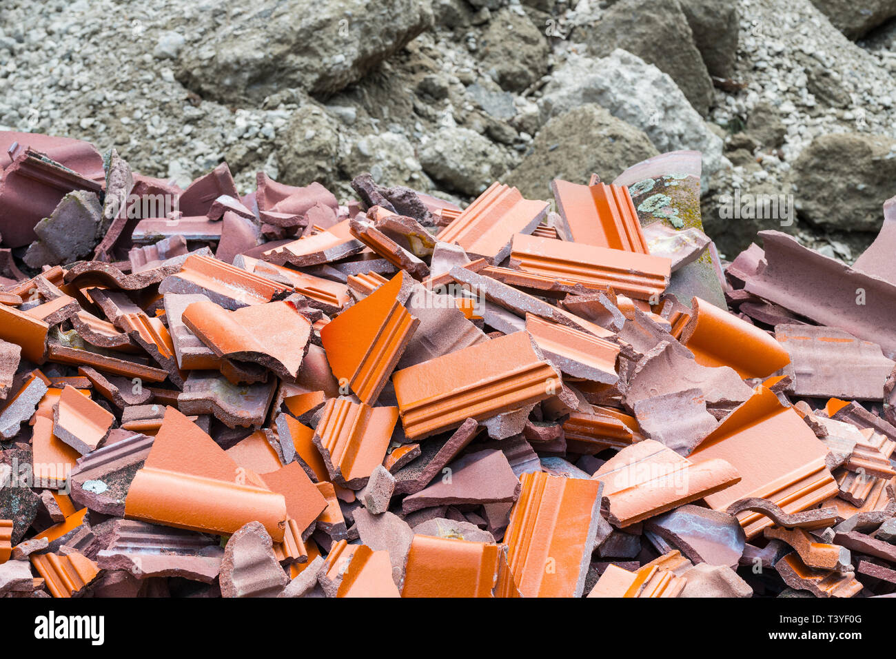 Tuile fissurée. Tas de gravats. Dépôt de déchets de construction détaillée. Pile de pièces en céramique cassée et débris de béton flou en arrière-plan. Ruines rouges. L'écologie. Banque D'Images