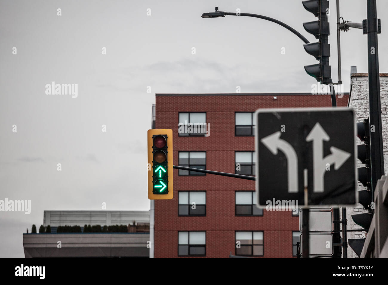 Feu de circulation respectant les normes américaines qui indiquent les deux directions avec feu vert, à un carrefour, avec un signe indiquant l'intersection avec la d Banque D'Images