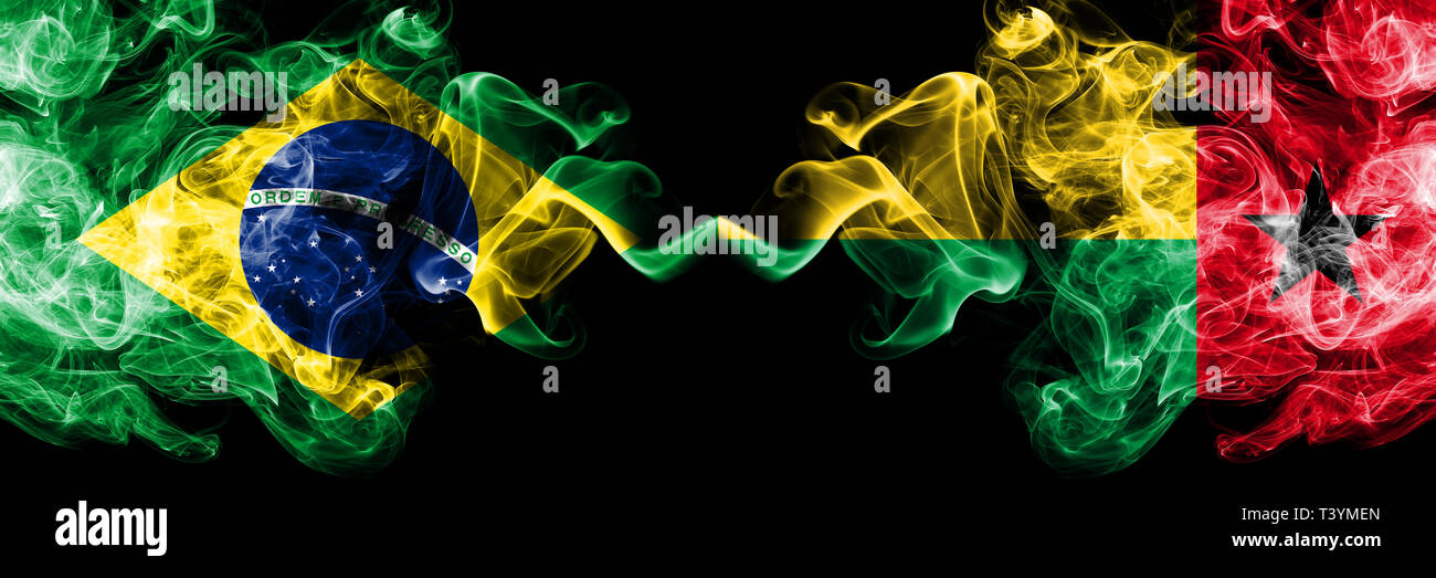 Brésil contre la Guinée Bissau drapeaux de fumée placés côte à côte. La fumée épaisse et soyeuse de couleur de drapeaux et brésilien Guinée Bissau Banque D'Images