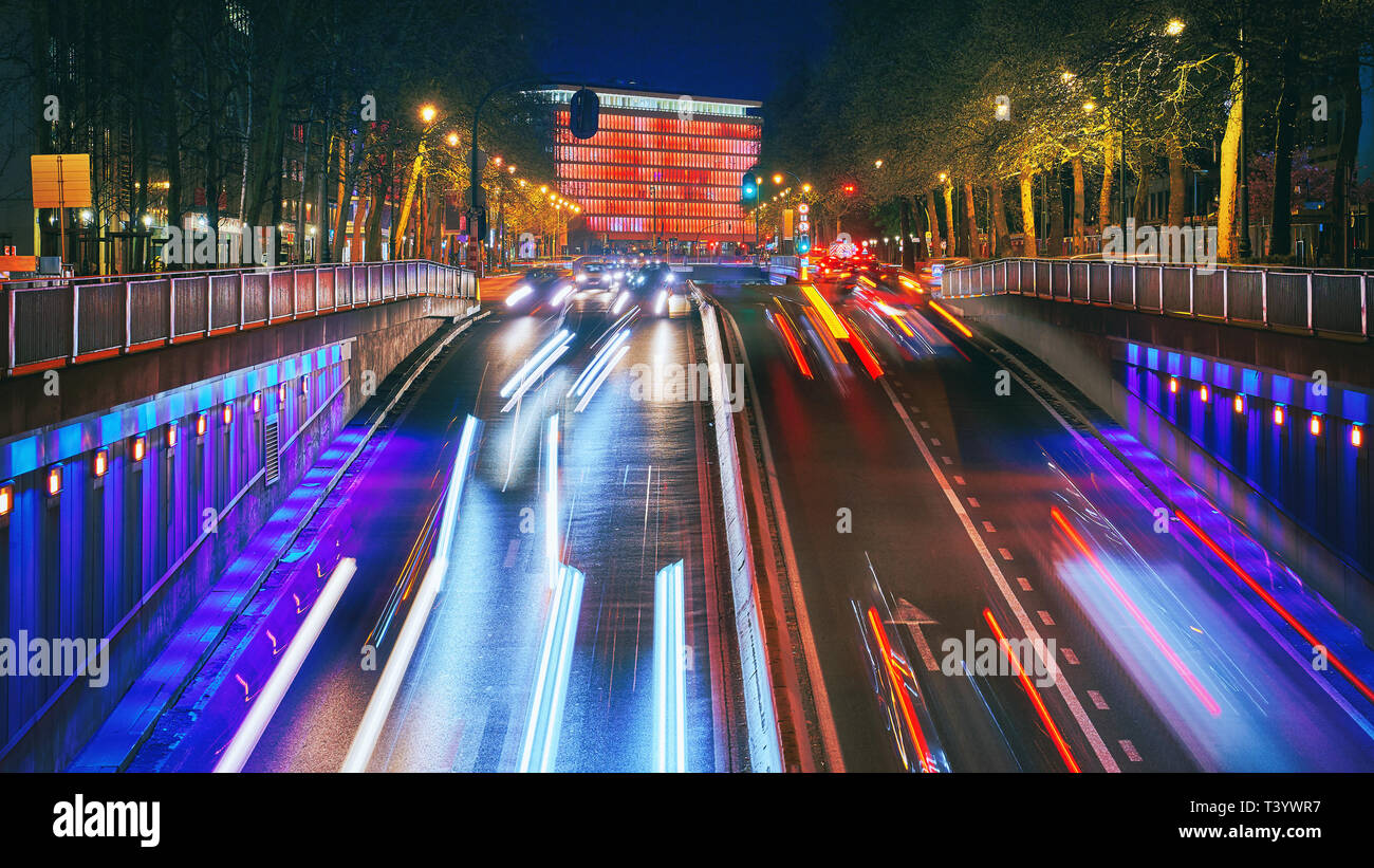 Une longue exposition shot d'une rue du centre-ville au coucher du soleil. Gratte-ciel sur l'arrière-plan avec des feux de circulation. Bruxelles, Belgique. Banque D'Images