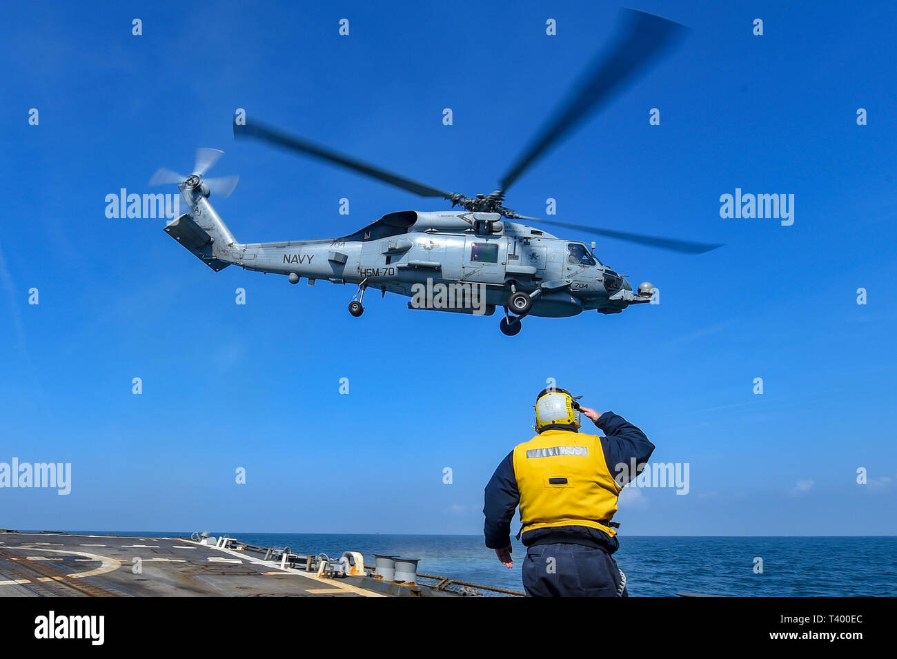 190411-N-JX484-437 MER DE HEBRIDES (avr. 11, 2019) Maître de Manœuvre 2e classe Eric Coleman dirige un MH-60R Seahawk hélicoptère des Spartiates de grève Maritime Squadron (70 HSM) hors de la cabine de pilotage à bord du destroyer lance-missiles USS gravement (DDG 107). Gravement sont en cours sur un déploiement de service comme le fleuron du 1er Groupe maritime permanent de l'OTAN à mener des opérations maritimes et fournir une capacité maritime continue de l'OTAN dans le nord de l'Atlantique. (U.S. Photo par marine Spécialiste de la communication de masse 2e classe Mark Andrew Hays/libérés) Banque D'Images