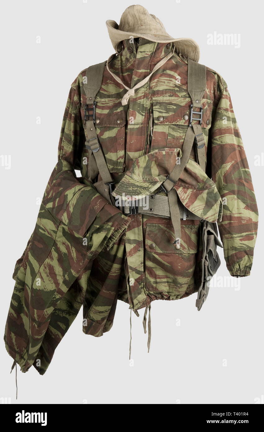 GUERRE D'INDOCHINE - GUERRE D'ALGÉRIE, ensemble veste et pantalon camouflé, 47/56, et beaucoup de petits équipements. Veste en toile bariolée avec ses pressions "DOT durable RG', couleurs fraîches, bas des manches à élastiques, fermetures à glissière Mme Elless' avec 'Avenue, les tampons intérieurs 'A-2548', 'J.Pauwels & Cie Merville', 'NH' et tampons inconnus, also visibles à l'extérieur. Pantalon frais au niveau des couleurs, avec ses boutons, pressions, les tampons intérieurs 'UNE Pourchaux Béthune', 'NH' et étiquette tissu '27'. Chapeau de brousse en toile beige, œillets, en aluminium , Editorial-Use-seulement Banque D'Images