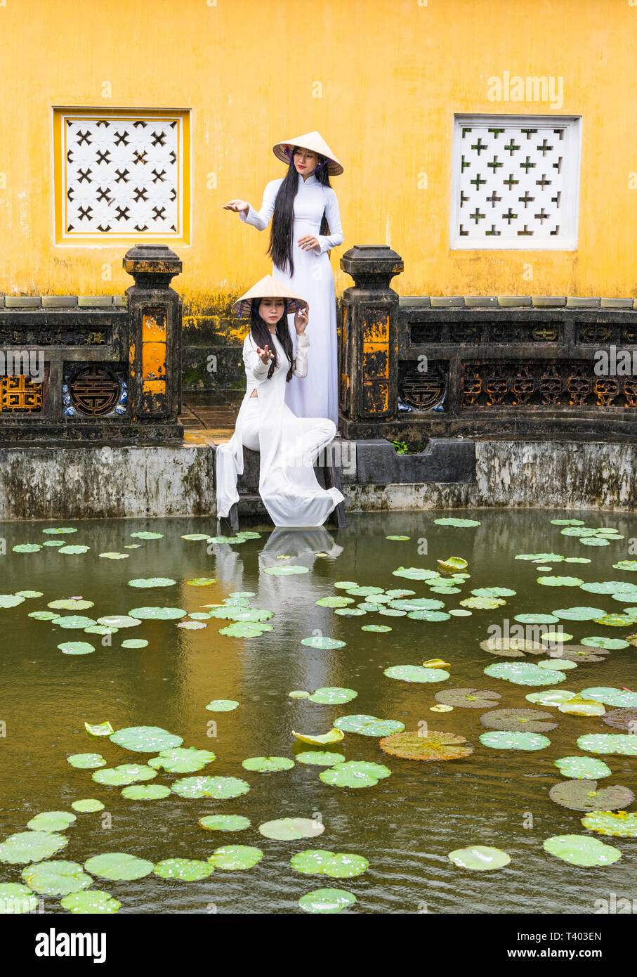Les jeunes femmes portant des costumes nationaux traditionnels, ao dai, dans la ville impériale, Hue, Vietnam Banque D'Images