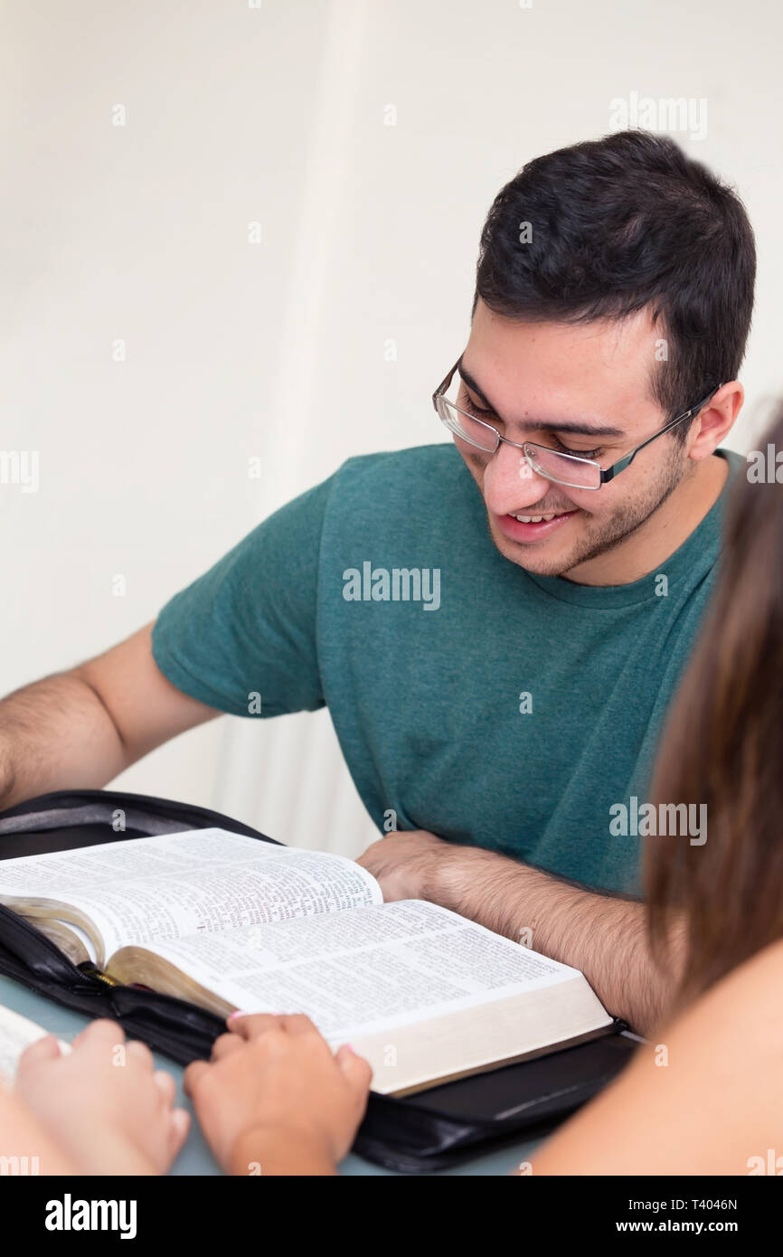 Jeune homme lire la Bible avec un sourire Banque D'Images