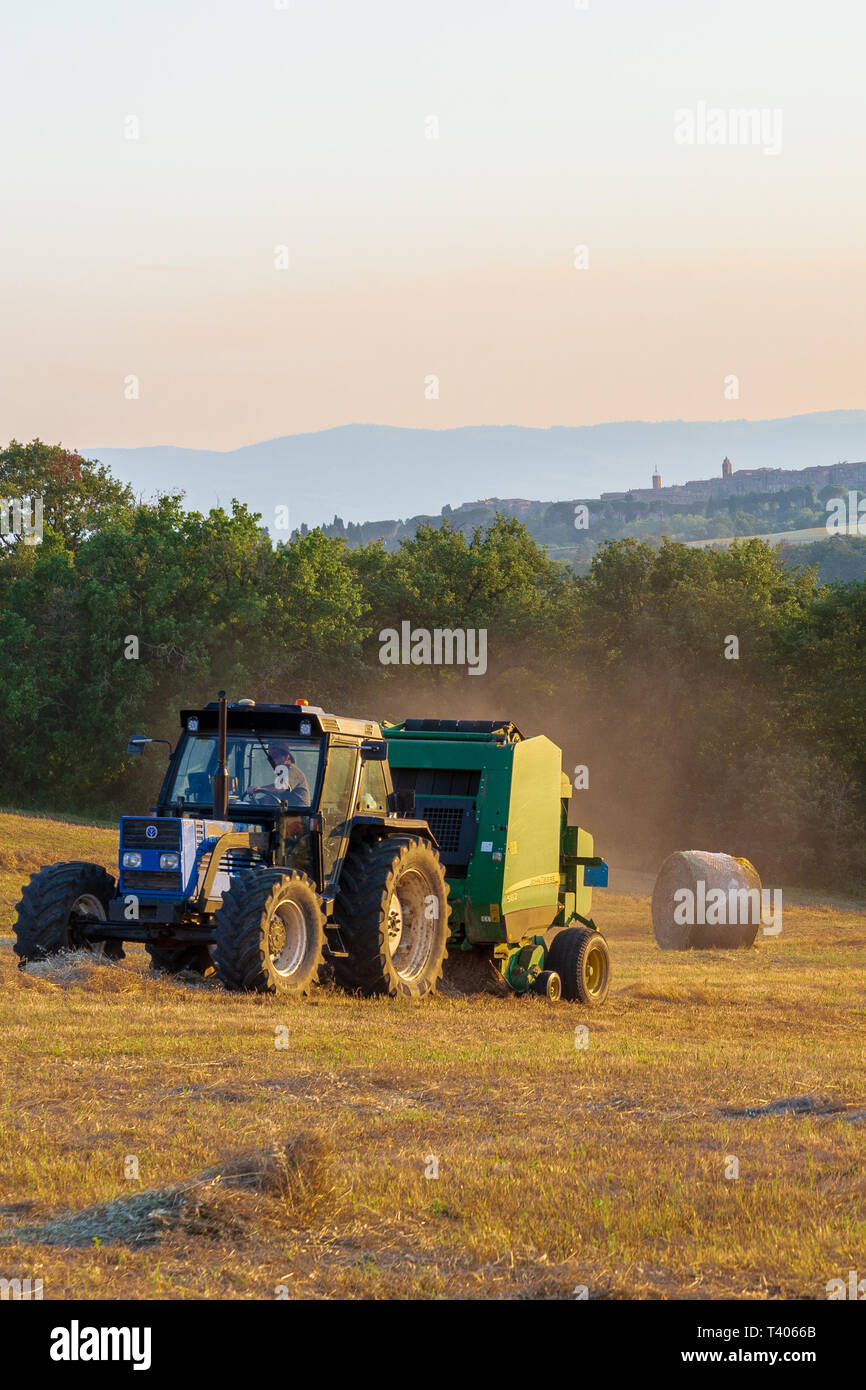 18 juin 2018, Belgrade, Ombrie, Italie : une presse à balles de foin au travail dans un champ que le soleil se couche. Banque D'Images
