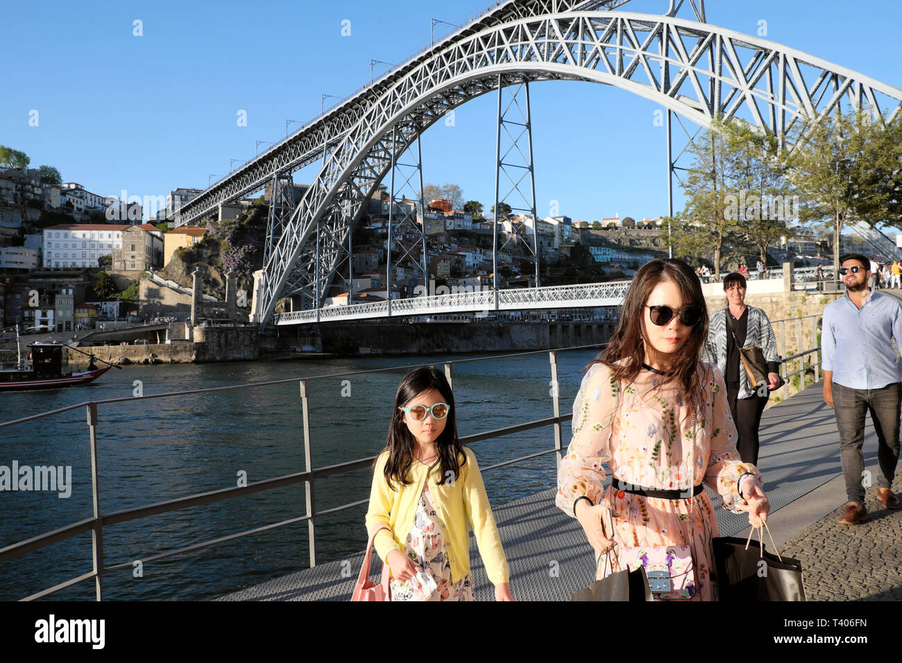 Femme et enfant élégants touristes marcher sur le Cais de Gaia à Vila Nova de Gaia, côté de la rivière Douro et de vue de Pont Dom Luis Porto Portugal UE Banque D'Images Femme et enfant élégants touristes marcher sur le Cais de Gaia à Vila Nova de Gaia, côté de la rivière Douro et de vue de Pont Dom Luis Porto Portugal UE Banque D'Images