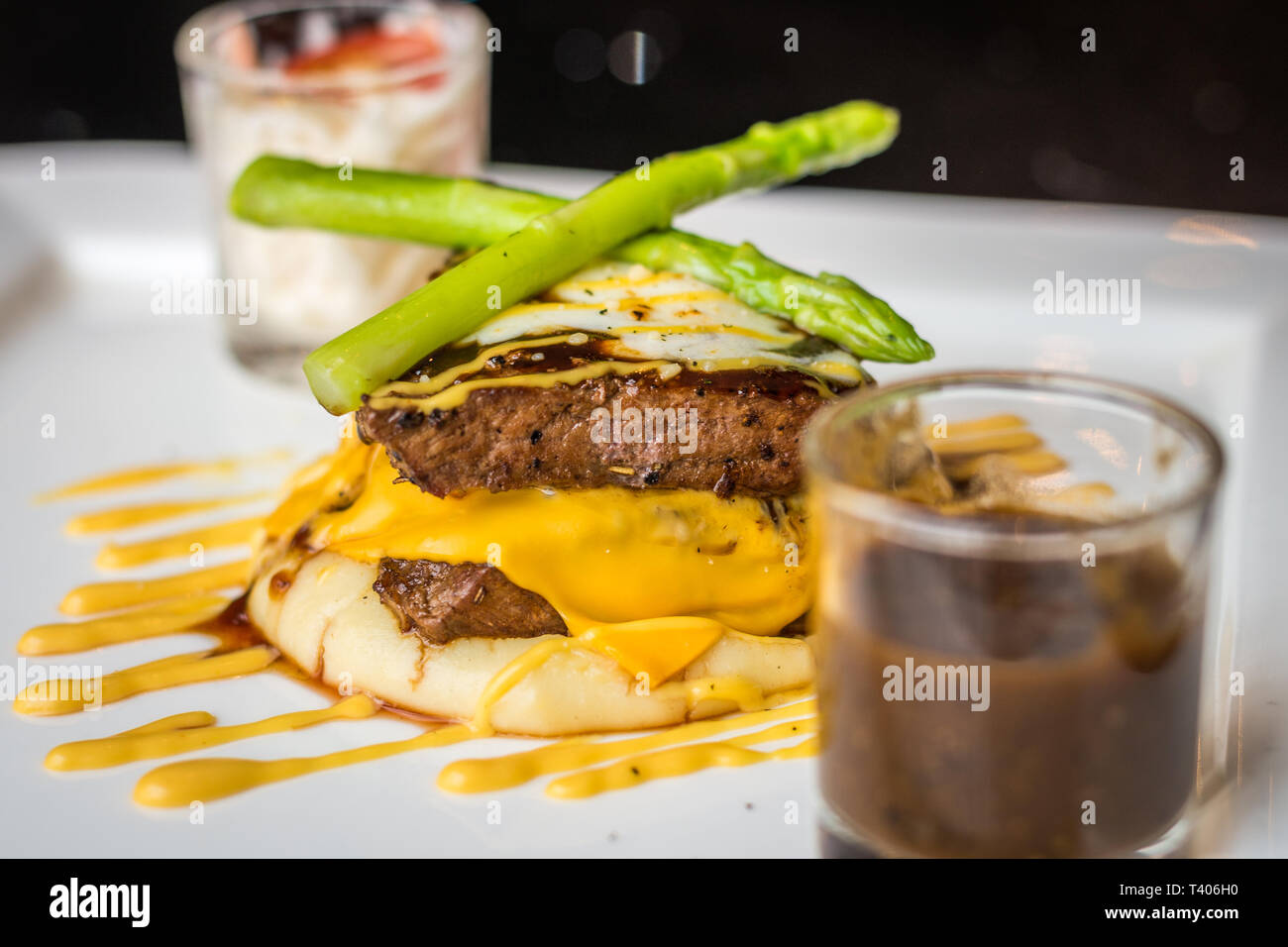 200g de steak de surlonge garnie de fromage américain sauce, parmesan, mozzarella, purée de pommes de terre et de choux Banque D'Images