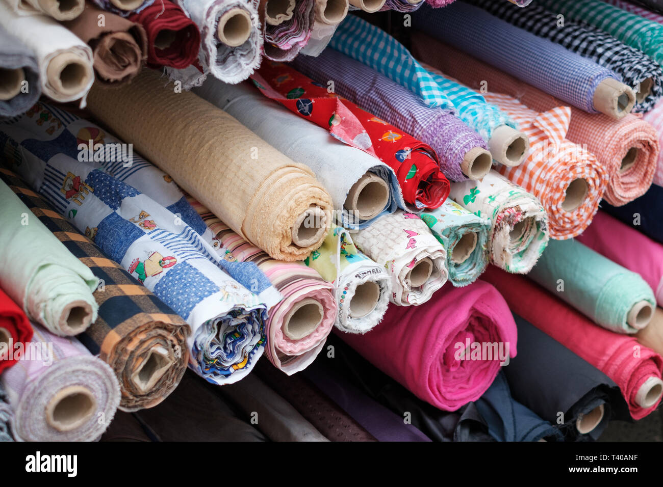 Rouleaux de tissus et textiles colorés sur le stand de marché Banque D'Images
