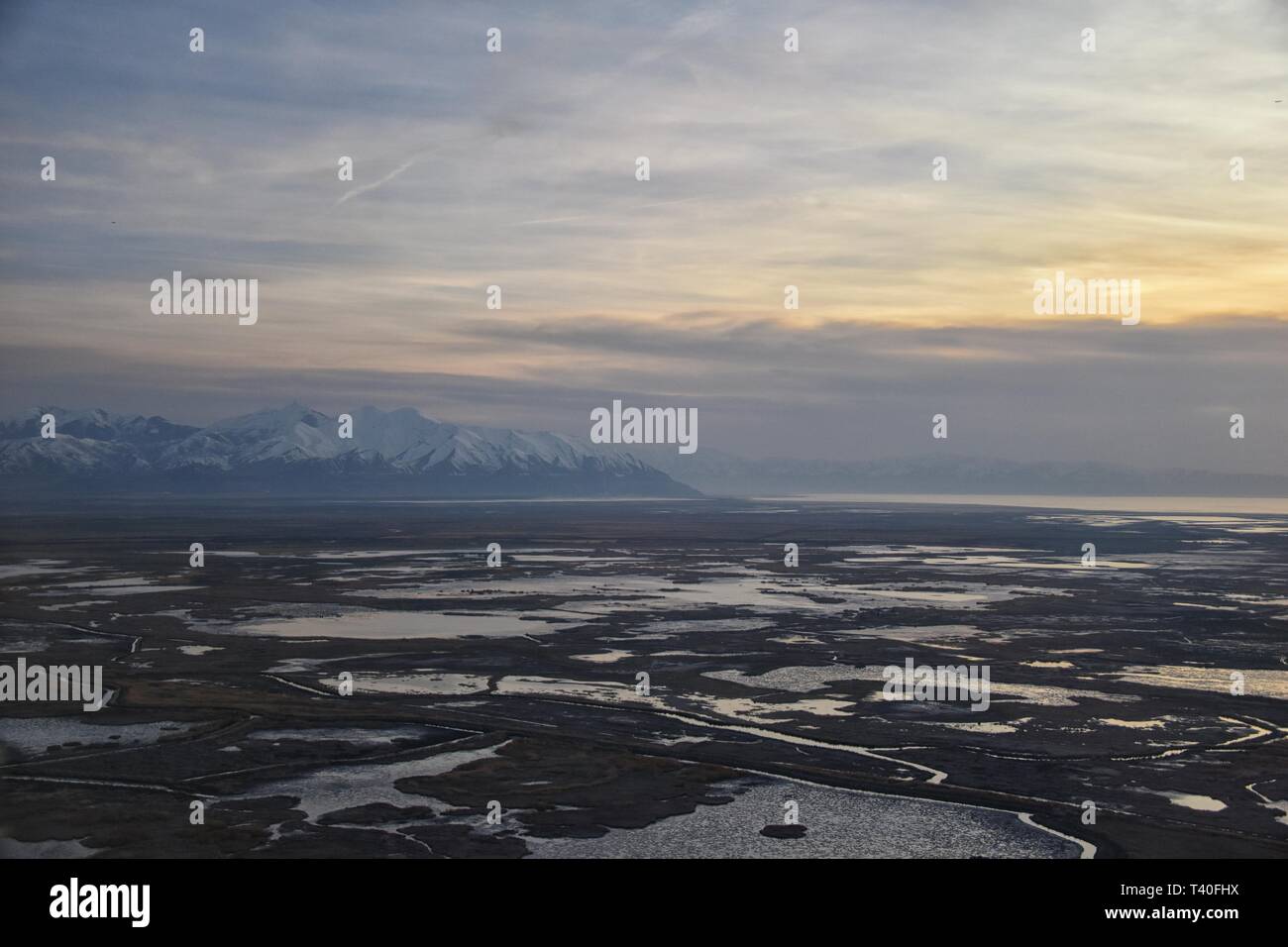 Vue aérienne de l'avion d'Antelope Island au coucher du soleil, vue de Magna, balayant cloudscape au lever du soleil avec le Great Salt Lake State Park en hiver. Banque D'Images