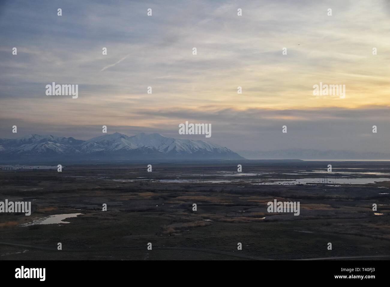 Vue aérienne de l'avion d'Antelope Island au coucher du soleil, vue de Magna, balayant cloudscape au lever du soleil avec le Great Salt Lake State Park en hiver. Banque D'Images