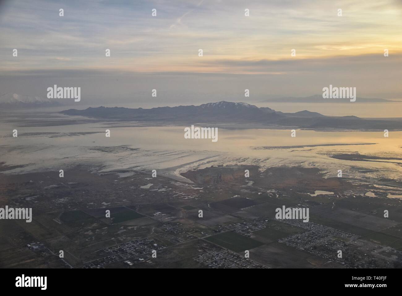 Vue aérienne de l'avion d'Antelope Island au coucher du soleil, vue de Magna, balayant cloudscape au lever du soleil avec le Great Salt Lake State Park en hiver. Banque D'Images