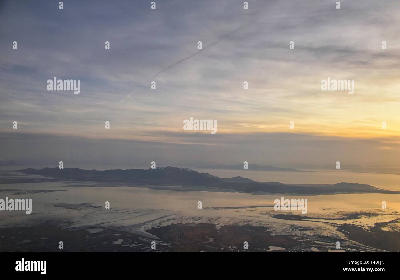 Vue aérienne de l'avion d'Antelope Island au coucher du soleil, vue de Magna, balayant cloudscape au lever du soleil avec le Great Salt Lake State Park en hiver. Banque D'Images