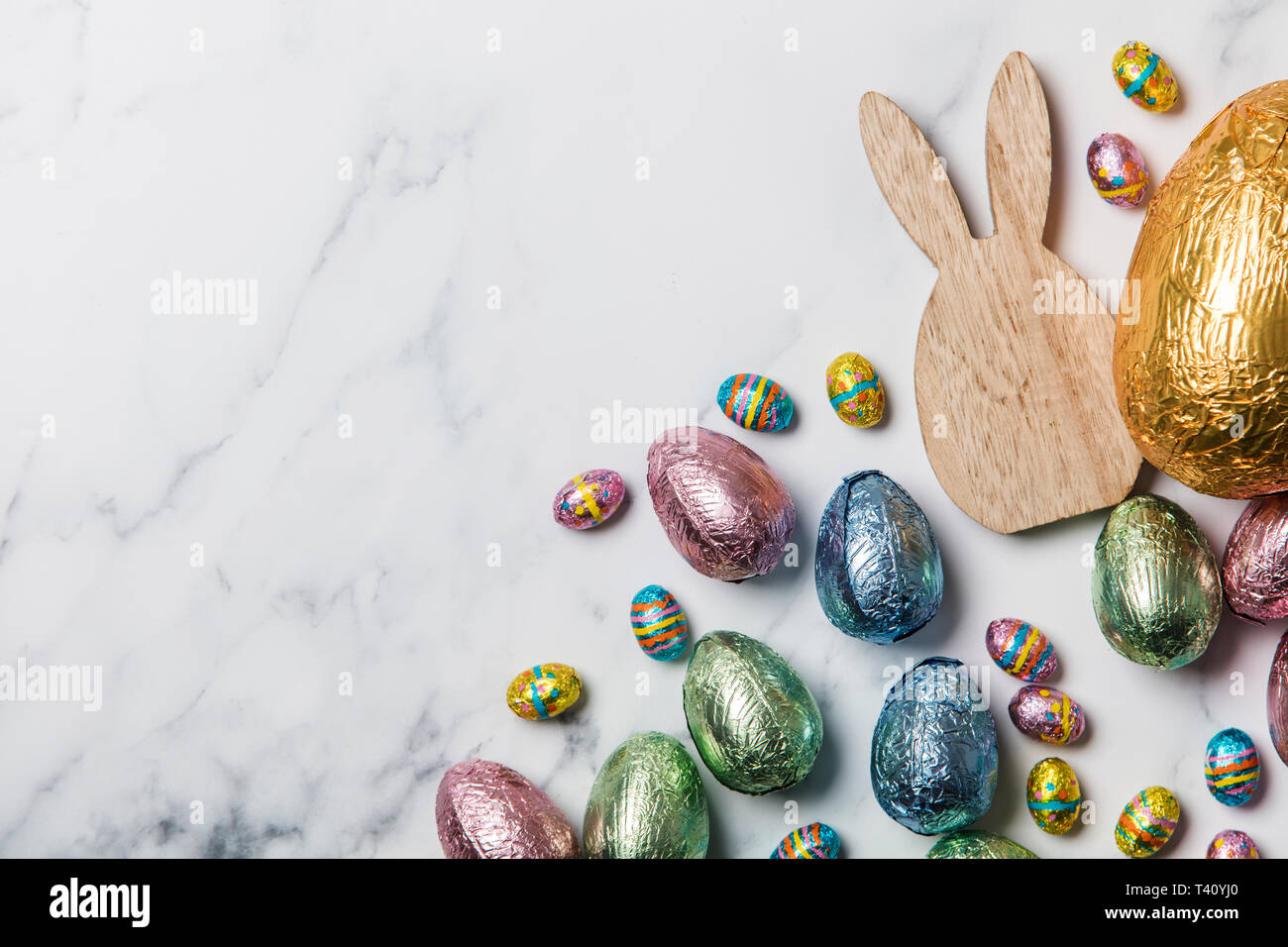 Lapin de Pâques avec les oeufs de pâques en chocolat emballé d'aluminium Banque D'Images